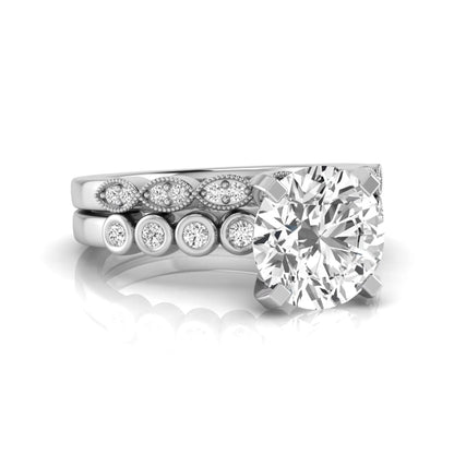 Round cut lab grown diamond bridal ring set featuring a four-prong solitaire engagement ring with a matching side stone wedding band accented by round bezel-set diamonds and vintage milgrain detailing in white gold