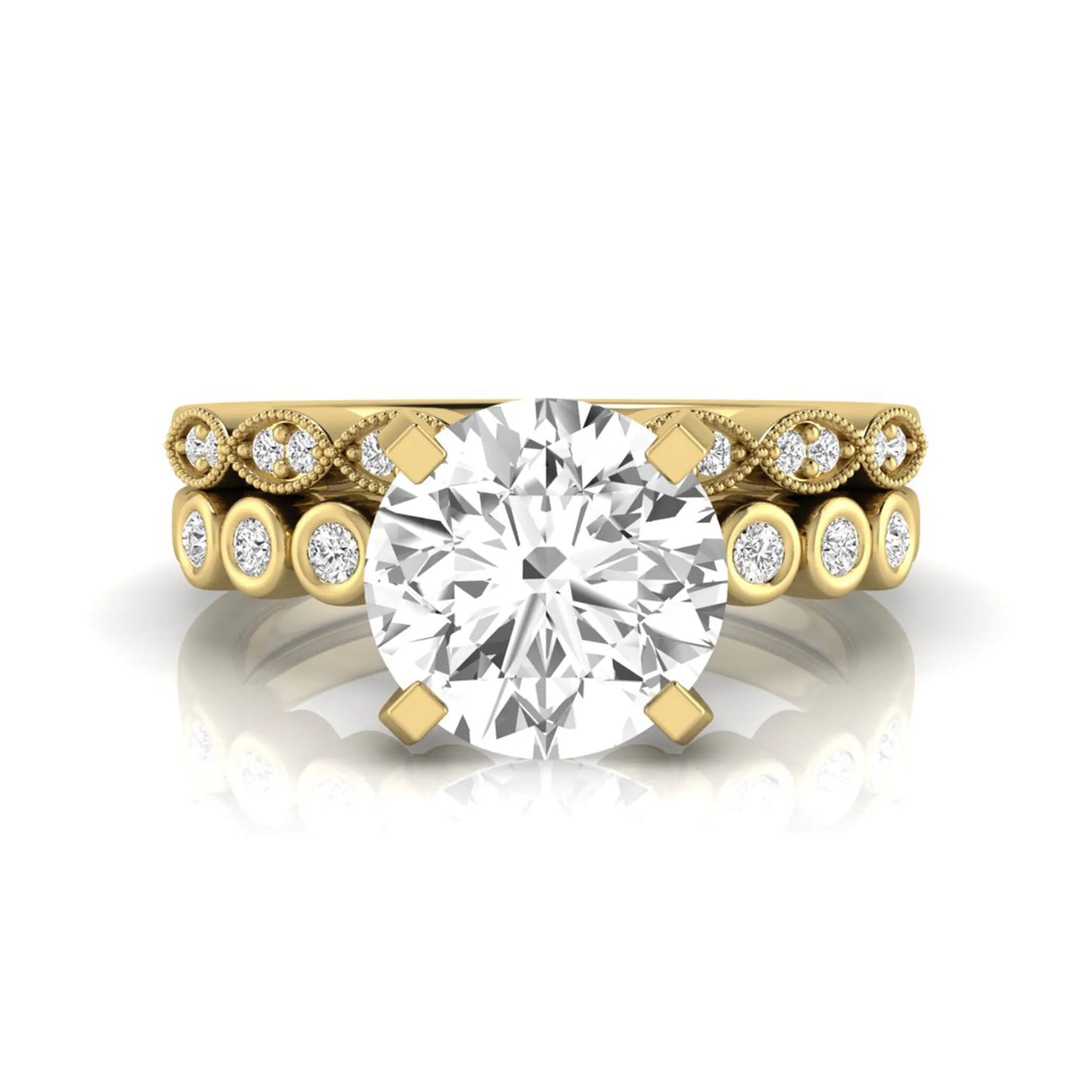 Round cut lab grown diamond bridal ring set featuring a four-prong solitaire engagement ring with a matching side stone wedding band accented by round bezel-set diamonds and vintage milgrain detailing in yellow gold