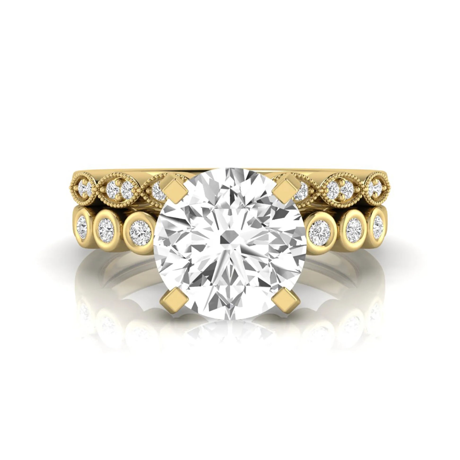 Round cut lab grown diamond bridal ring set featuring a four-prong solitaire engagement ring with a matching side stone wedding band accented by round bezel-set diamonds and vintage milgrain detailing in yellow gold