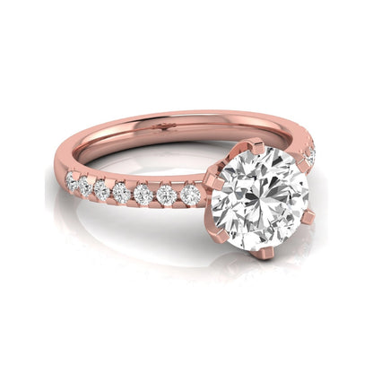 Round cut lab grown diamond solitaire engagement ring featuring a six-prong setting with a pavé diamond band in rose gold tone.