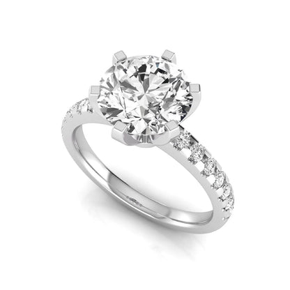 Round cut lab grown diamond solitaire engagement ring featuring a six-prong setting with a pavé diamond band in white gold tone.