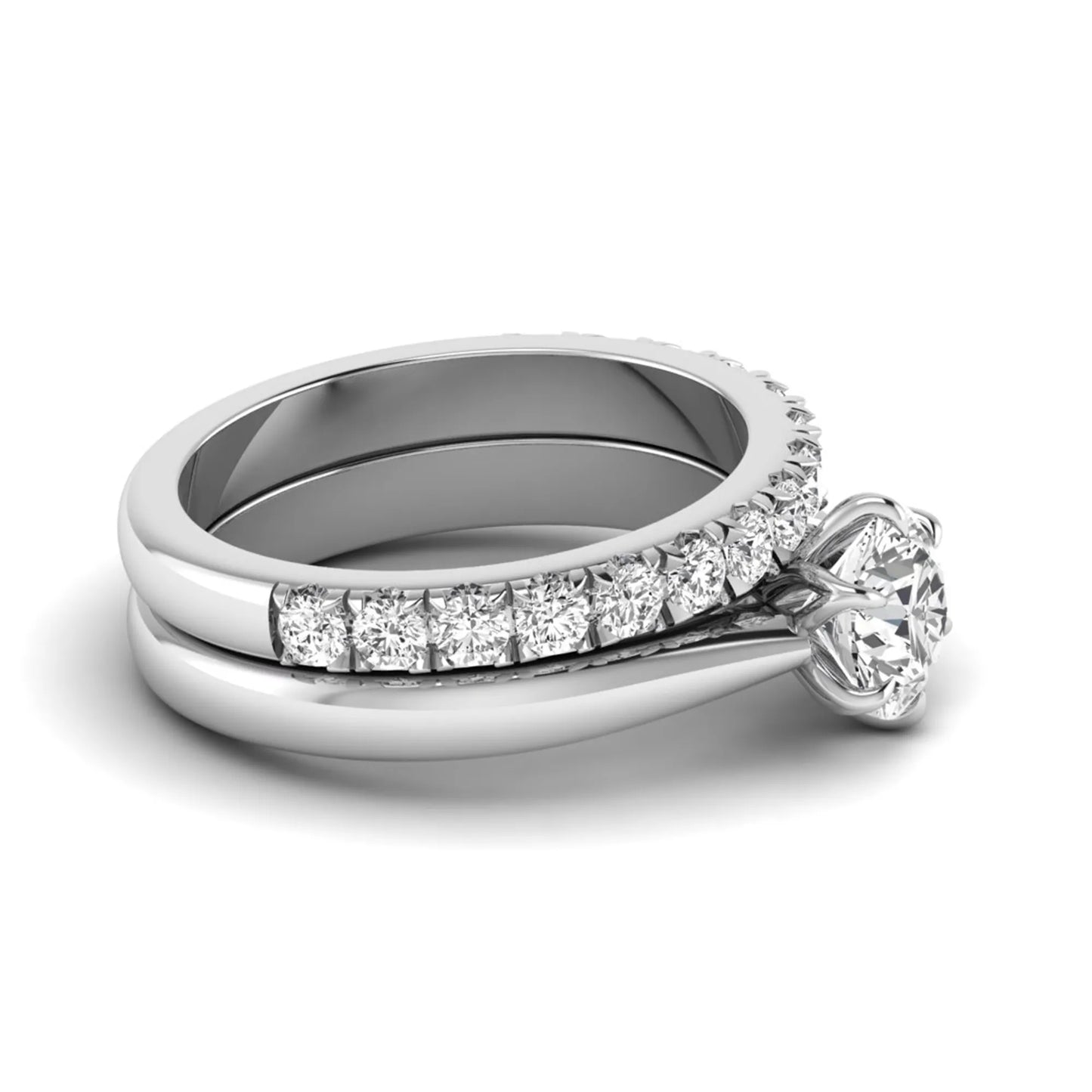 Round cut lab grown diamond solitaire bridal ring set featuring a six-prong engagement ring with a matching shared-prong round diamond wedding band in white gold tone design.