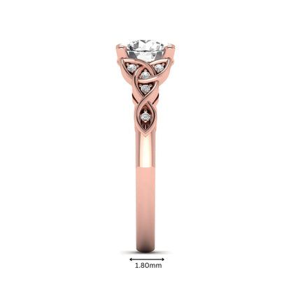 Round cut lab grown diamond solitaire engagement ring featuring a four-prong center diamond with an intricate Celtic knot-inspired band and round accent diamonds in a rose gold finish.