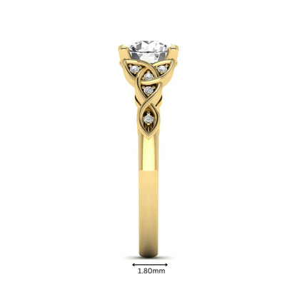 Round cut lab grown diamond solitaire engagement ring featuring a four-prong center diamond with an intricate Celtic knot-inspired band and round accent diamonds in a yellow gold finish.
