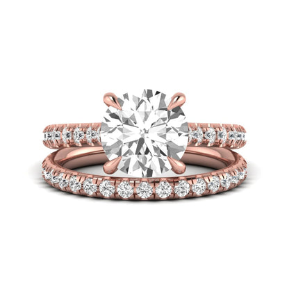 Round cut lab grown diamond bridal ring set featuring a four-prong solitaire center diamond with pavé-set engagement ring and matching pavé wedding band in a rose gold finish.