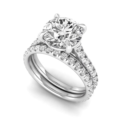 Round cut lab grown diamond bridal ring set featuring a four-prong solitaire center diamond with pavé-set engagement ring and matching pavé wedding band in a white gold finish.