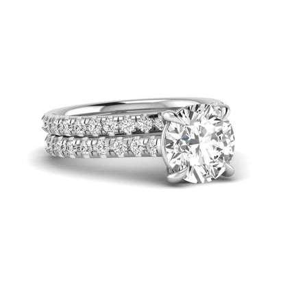 Round cut lab grown diamond bridal ring set featuring a four-prong solitaire center diamond with pavé-set engagement ring and matching pavé wedding band in a white gold finish.