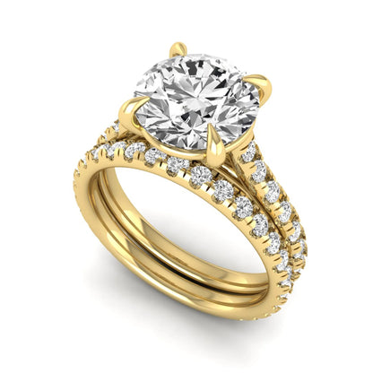 Round cut lab grown diamond bridal ring set featuring a four-prong solitaire center diamond with pavé-set engagement ring and matching pavé wedding band in a yellow gold finish.