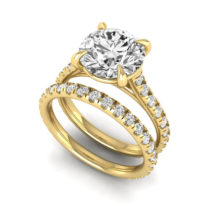 Round cut lab grown diamond bridal ring set featuring a four-prong solitaire center diamond with pavé-set engagement ring and matching pavé wedding band in a yellow gold finish.