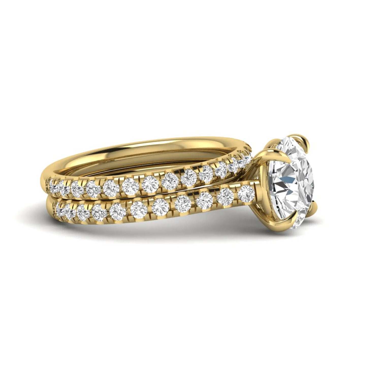 Round cut lab grown diamond bridal ring set featuring a four-prong solitaire center diamond with pavé-set engagement ring and matching pavé wedding band in a yellow gold finish.