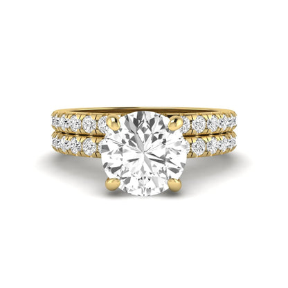 Round cut lab grown diamond solitaire bridal ring set featuring pavé diamond bands in a yellow gold tone design.