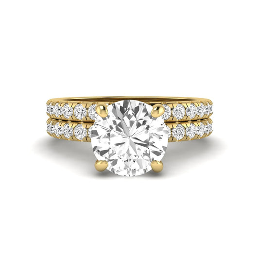 Round cut lab grown diamond solitaire bridal ring set featuring pavé diamond bands in a yellow gold tone design.