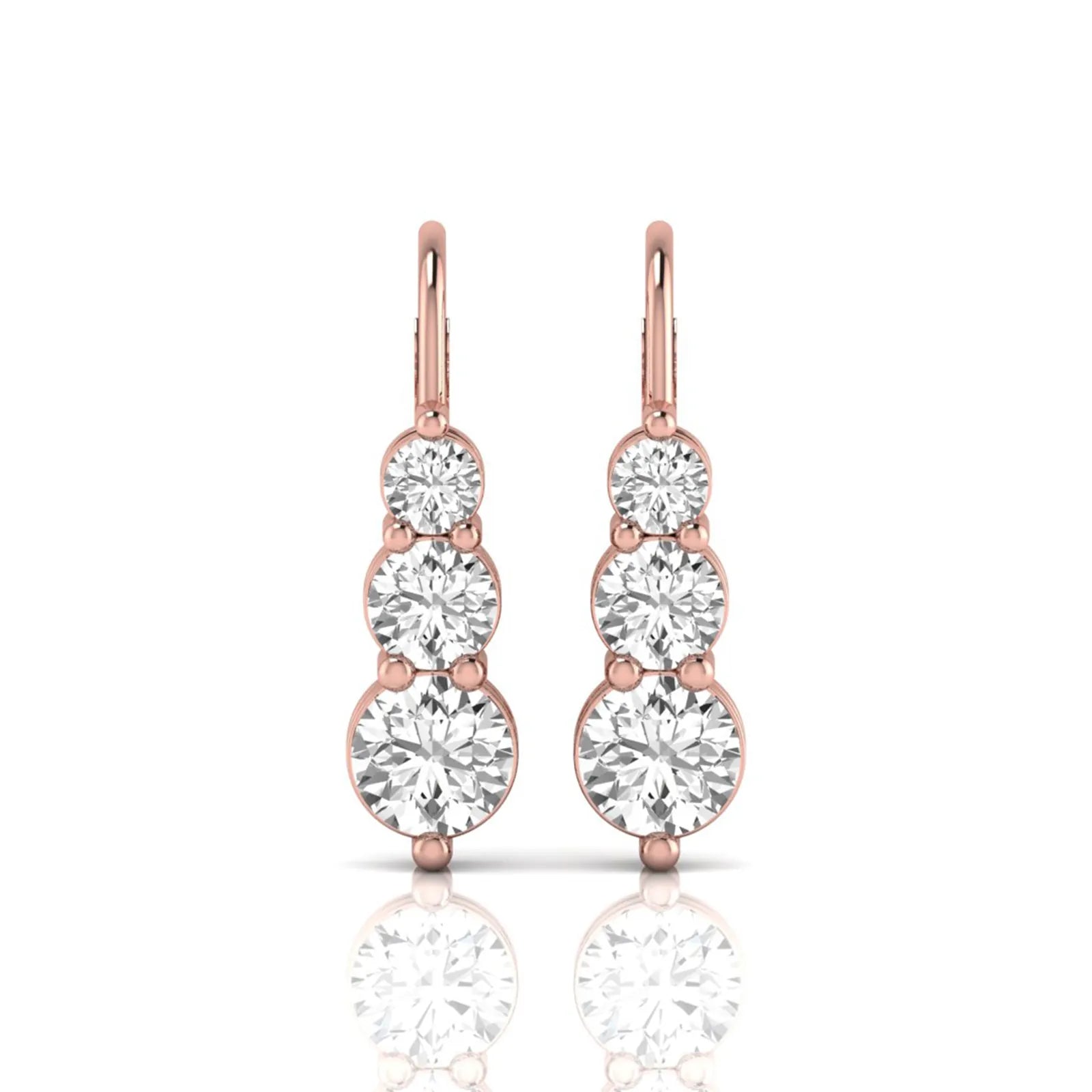 Round cut lab grown diamond graduated three stone drop earrings featuring a shared four-prong setting with secure lever back closure and rose gold tone design.