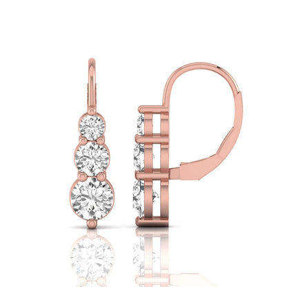 Round cut lab grown diamond graduated three stone drop earrings featuring a shared four-prong setting with secure lever back closure and rose gold tone design.