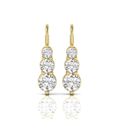 Round cut lab grown diamond graduated three stone drop earrings featuring a shared four-prong setting with secure lever back closure and yellow gold tone design.
