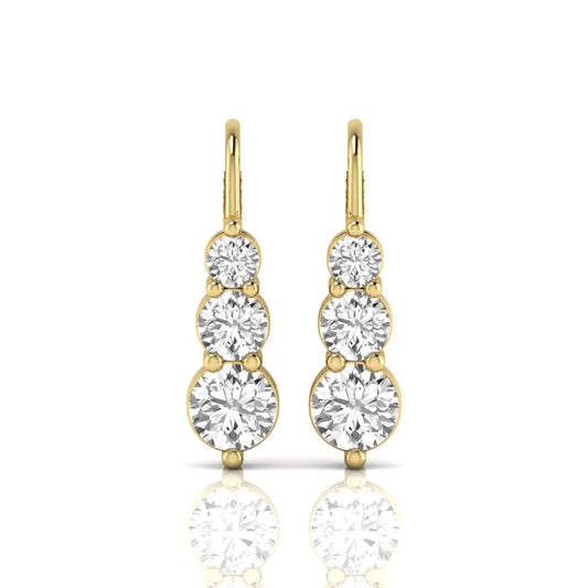 Round cut lab grown diamond graduated three stone drop earrings featuring a shared four-prong setting with secure lever back closure and yellow gold tone design.