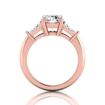 Round cut lab grown diamond three-stone engagement ring featuring tapered baguette side diamonds in a classic four-prong rose gold setting.