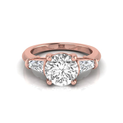 Round cut lab grown diamond three-stone engagement ring featuring tapered baguette side diamonds in a classic four-prong rose gold setting.
