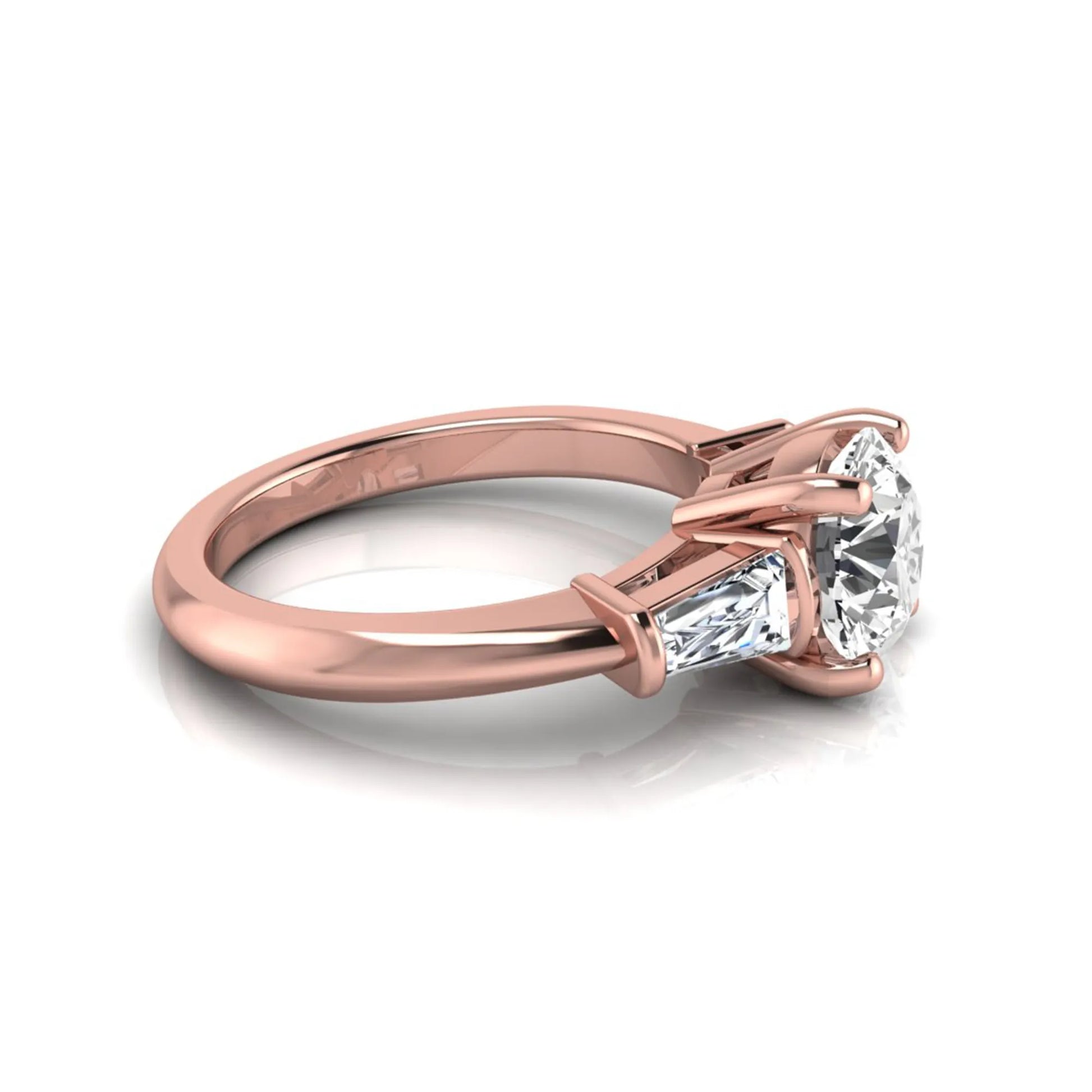 Round cut lab grown diamond three-stone engagement ring featuring tapered baguette side diamonds in a classic four-prong rose gold setting.