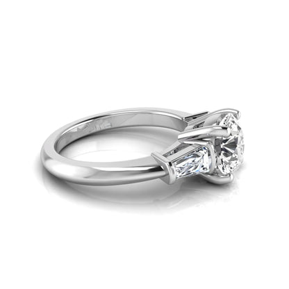 Round cut lab grown diamond three-stone engagement ring featuring tapered baguette side diamonds in a classic four-prong white gold setting.