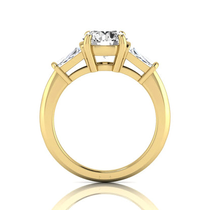Round cut lab grown diamond three-stone engagement ring featuring tapered baguette side diamonds in a classic four-prong yellow gold setting.