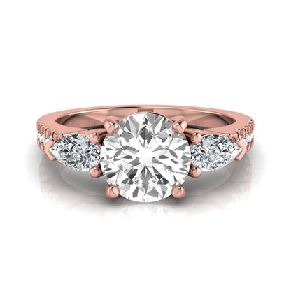 Round cut lab grown diamond three stone engagement ring featuring a 1.28 carat IGI certified center diamond with pear and round side diamonds on a pavé rose gold band.