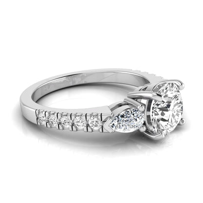Round cut lab grown diamond three stone engagement ring featuring a 1.28 carat IGI certified center diamond with pear and round side diamonds on a pavé white gold band.
