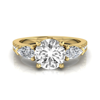 Round cut lab grown diamond three stone engagement ring featuring a 1.28 carat IGI certified center diamond with pear and round side diamonds on a pavé yellow gold band.