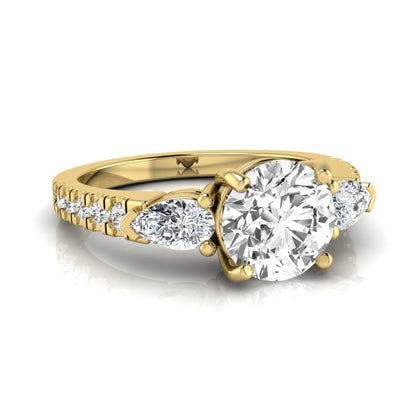 Round cut lab grown diamond three stone engagement ring featuring a 1.28 carat IGI certified center diamond with pear and round side diamonds on a pavé yellow gold band.