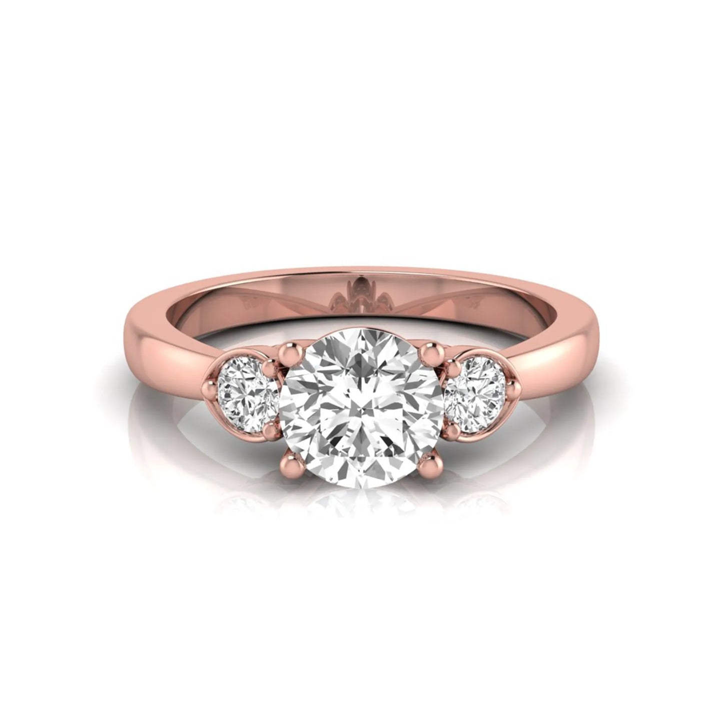 Round cut lab grown diamond three stone engagement ring featuring a brilliant center diamond with round side diamonds in a four-prong rose gold tone setting.