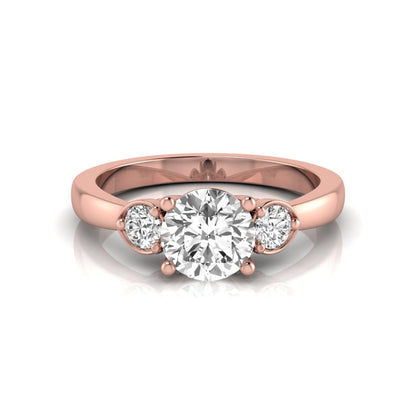 Round cut lab grown diamond three stone engagement ring featuring a brilliant center diamond with round side diamonds in a four-prong rose gold tone setting.