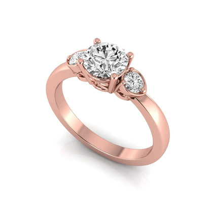 Round cut lab grown diamond three stone engagement ring featuring a brilliant center diamond with round side diamonds in a four-prong rose gold tone setting.