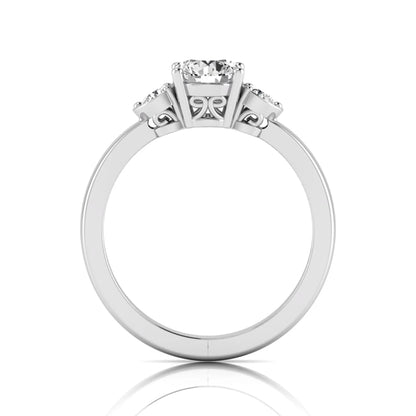 Round cut lab grown diamond three stone engagement ring featuring a brilliant center diamond with round side diamonds in a four-prong white gold tone setting.