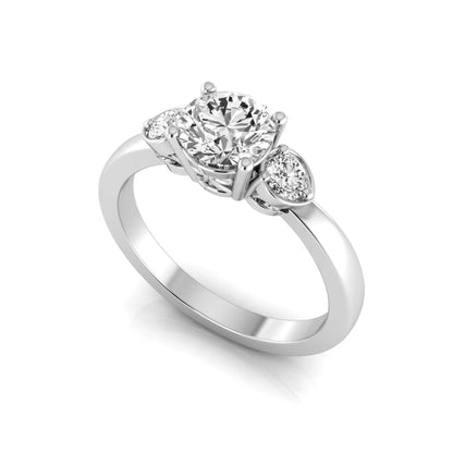Round cut lab grown diamond three stone engagement ring featuring a brilliant center diamond with round side diamonds in a four-prong white gold tone setting.