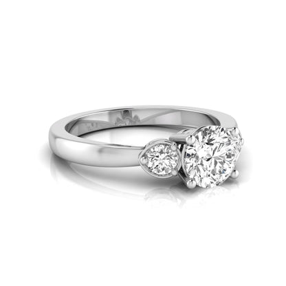 Round cut lab grown diamond three stone engagement ring featuring a brilliant center diamond with round side diamonds in a four-prong white gold tone setting.