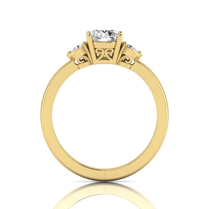 Round cut lab grown diamond three stone engagement ring featuring a brilliant center diamond with round side diamonds in a four-prong yellow gold tone setting.