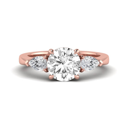 Round three stone prong set lab grown diamond engagement ring featuring a 2.00 carat round center diamond with pear cut side diamonds in rose gold finish.