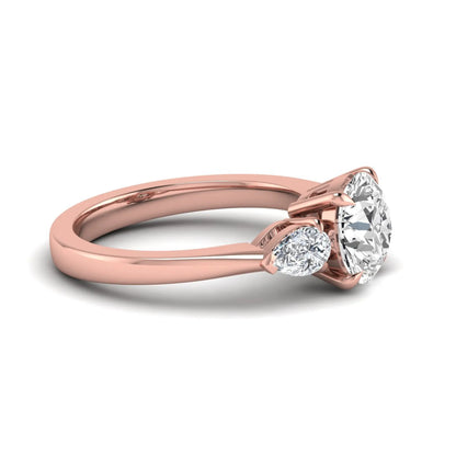 Round three stone prong set lab grown diamond engagement ring featuring a 2.00 carat round center diamond with pear cut side diamonds in rose gold finish.
