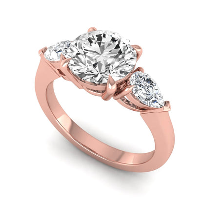 Round three stone prong set lab grown diamond engagement ring featuring a 2.00 carat round center diamond with pear cut side diamonds in rose gold finish.