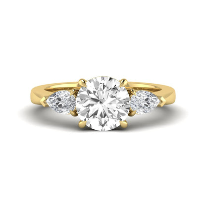 Round three stone prong set lab grown diamond engagement ring featuring a 2.00 carat round center diamond with pear cut side diamonds in yellow gold finish.