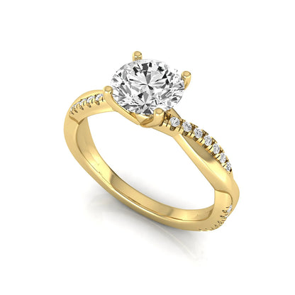 Round cut lab grown diamond engagement ring featuring a twisted pavé shank with a four-prong solitaire setting and polished yellow gold tone band.