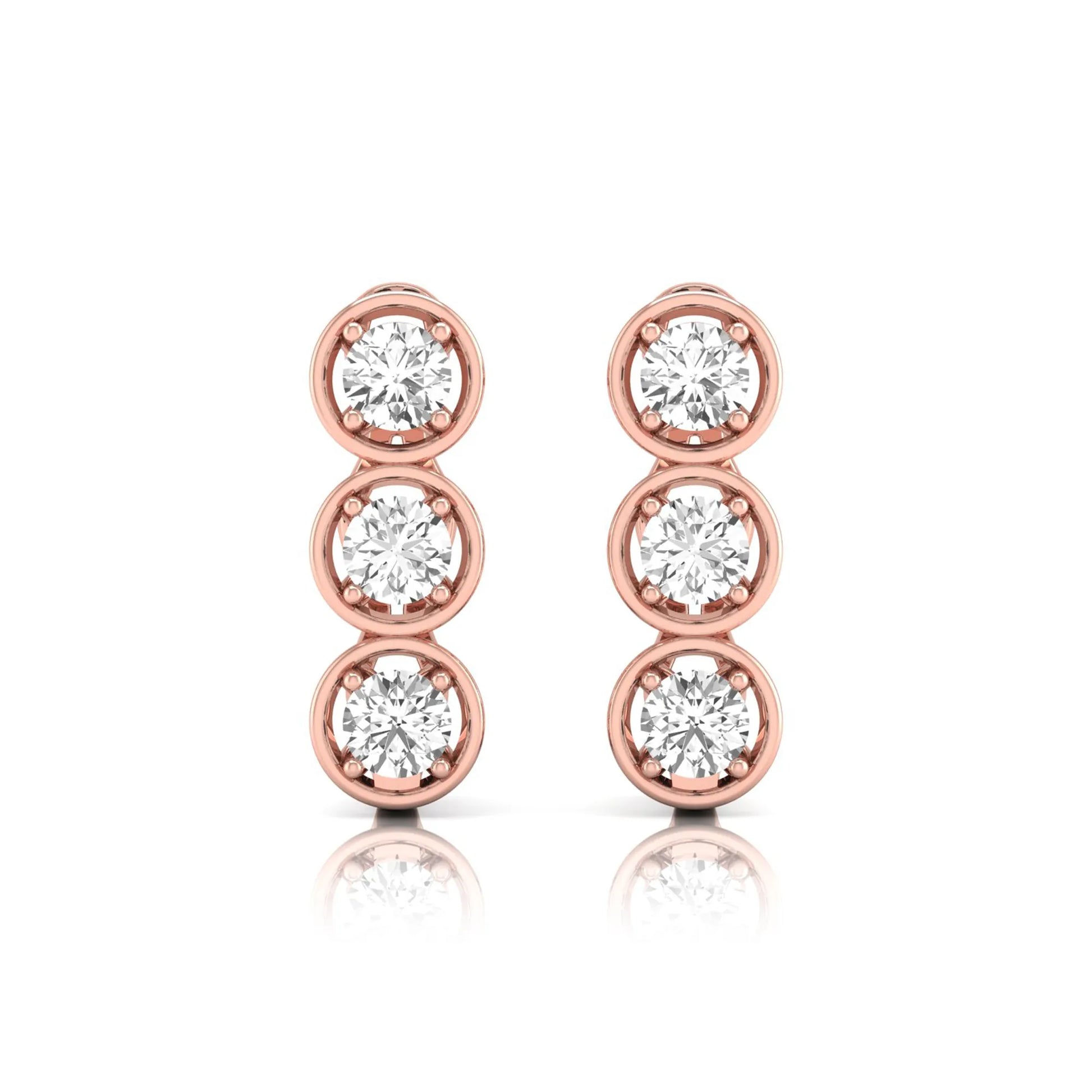 Three stone round cut lab grown diamond hoop earrings featuring bezel-inspired four prong settings, vertical diamond arrangement, hinged snap closure, and rose gold tone.