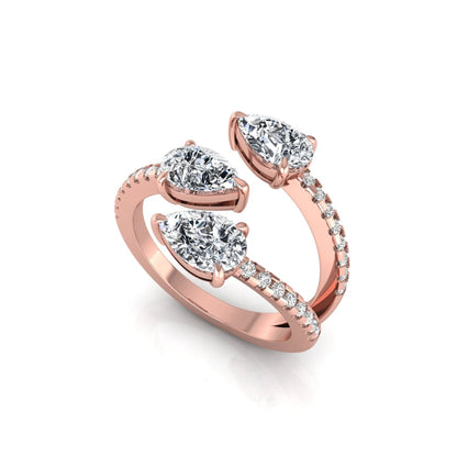 Three stone pear cut lab grown diamond wrap ring featuring round diamond accents and pavé shoulders in polished rose gold.