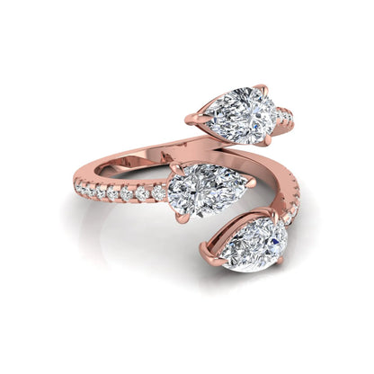 Three stone pear cut lab grown diamond wrap ring featuring round diamond accents and pavé shoulders in polished rose gold.