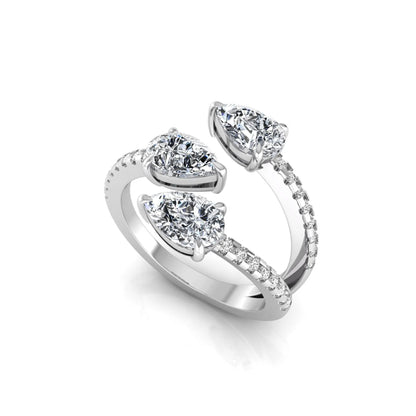 Three stone pear cut lab grown diamond wrap ring featuring round diamond accents and pavé shoulders in polished white gold.