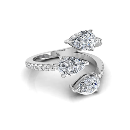 Three stone pear cut lab grown diamond wrap ring featuring round diamond accents and pavé shoulders in polished white gold.