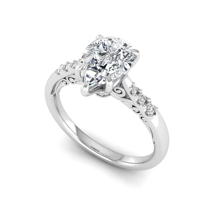 Vintage pear cut lab grown diamond engagement ring featuring an IGI certified center diamond, round diamond accents, and an ornate scroll gallery in white gold.